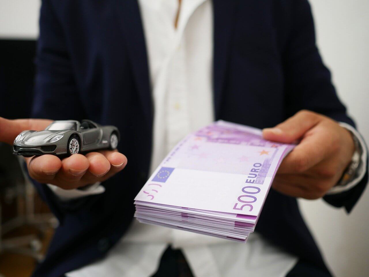 На фото мужчина предлагает машину и деньги.