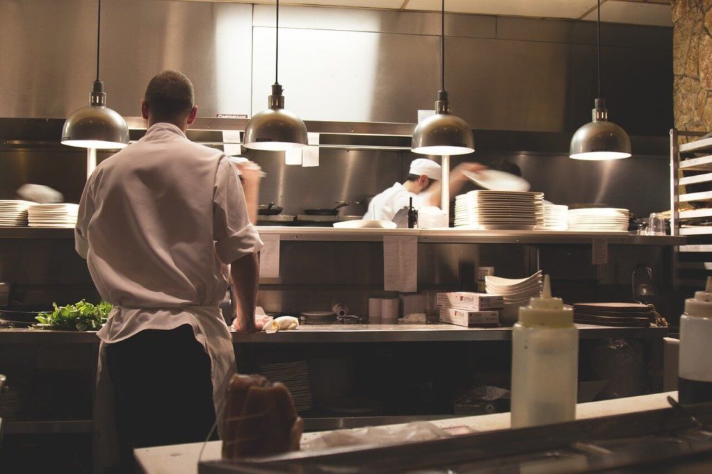 На фото изображены работники на кухне.